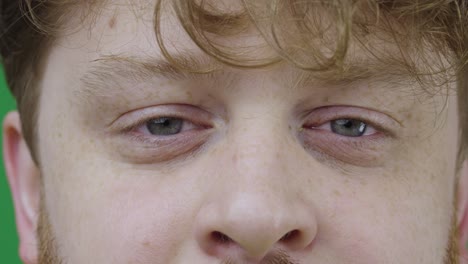 hombres ojos grises cerrados, seguidos de abiertos. hombre pelirrojo con cabello rizado y pecas mira directamente a la cámara. retrato macro de cerca. cámara lenta lista 59.97fps