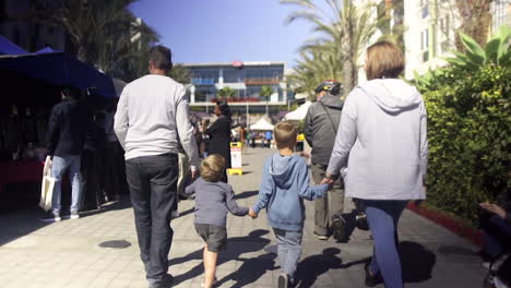 family walking on a sunny day in an outdoor market area