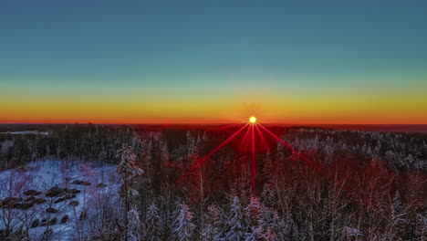 A-wintry-sunrise-behind-a-large-forest-first-turns-the-sky-orange-to-beautiful-blue-when-the-sun-is-high