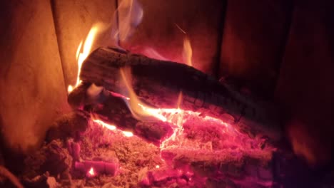 wood burning fireplace in home with white ash and burning hot orange bright flames providing heat to home during winter time