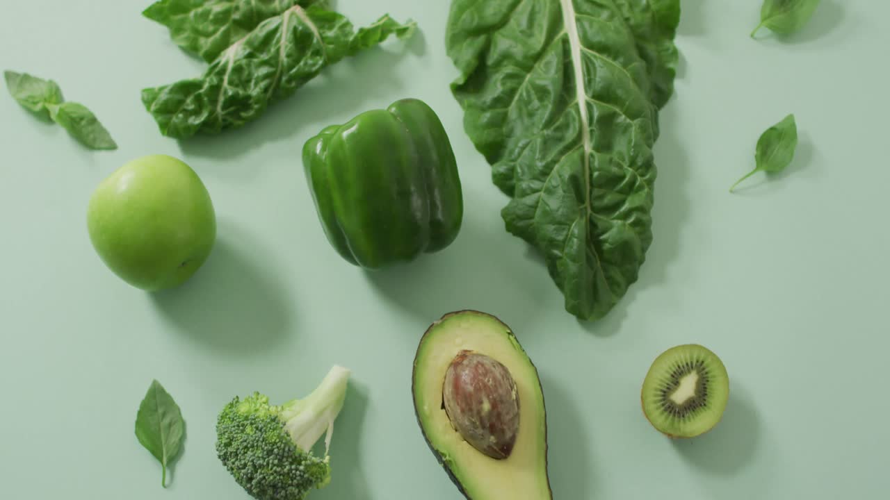 Video di avocado, broccoli, peperone verde, mela e foglie verdi freschi su sfondo verde