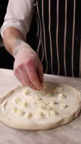 chef making pizza with cheese