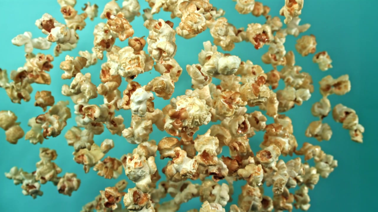 Golden Popcorn Kernels Floating on a Vibrant Blue Background