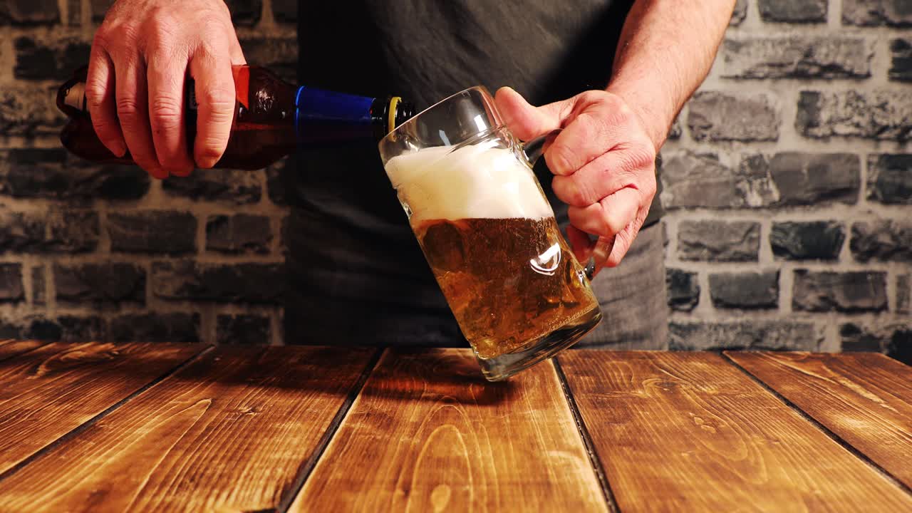 Closeup of filling a glass of beer with foam overflow and slowly floating down