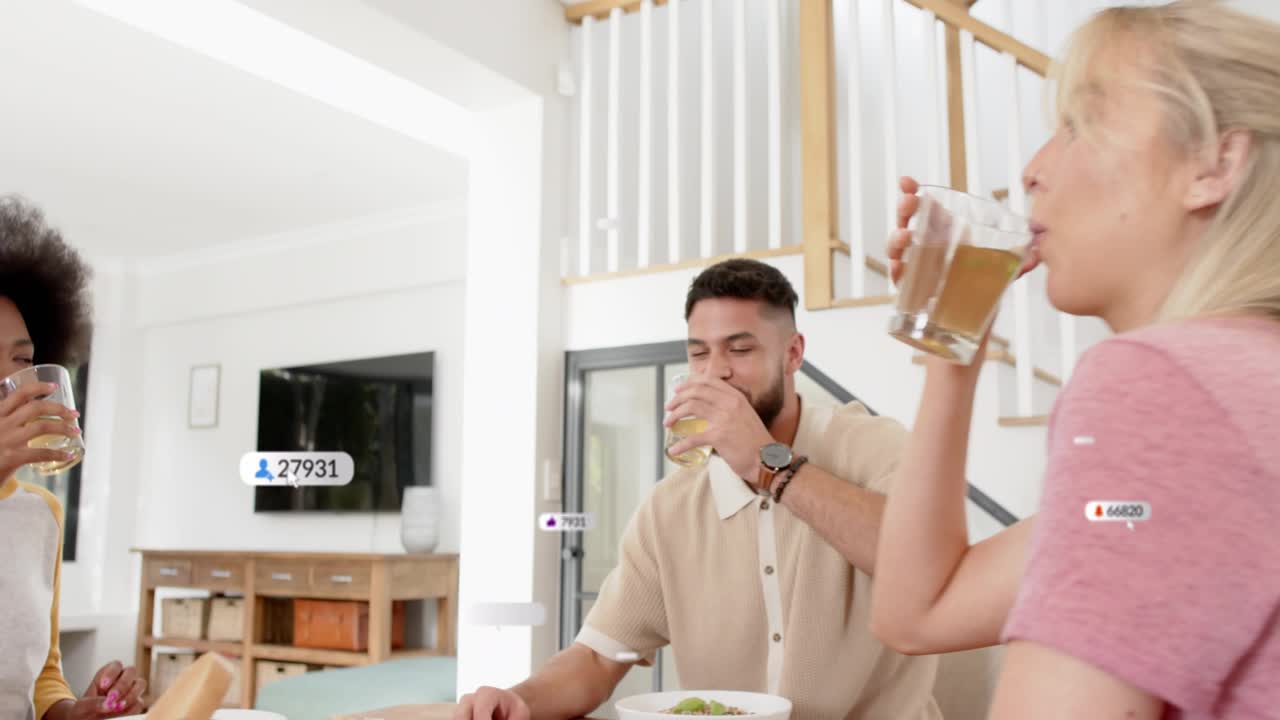 Group at table, one raising glass, social media badges popping around people, toasting