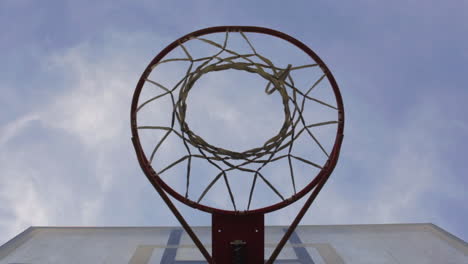 man throw ball on basketball hoop in playground at daytime