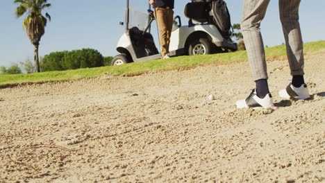 Video-of-legs-of-diverse-male-friends-playing-golf-on-golf-field