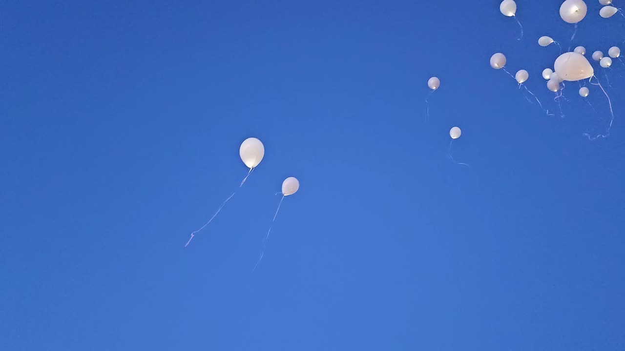 풍선이 풀려나서 바람에 싸여 높이 날아갑니다. 파란 하늘의 배경으로요.