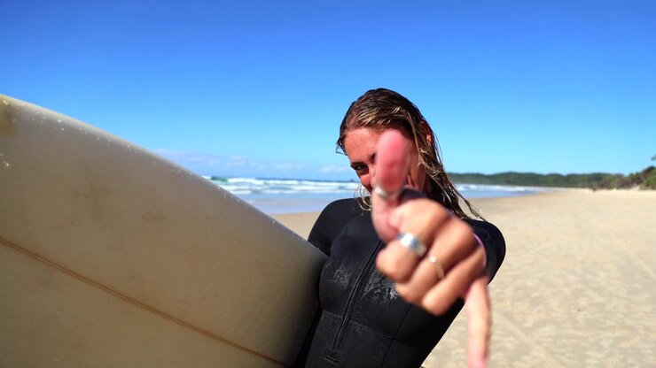 Happy Young Woman Surfer Making Shaka Sign on Sunny Beach