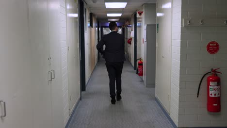 business man walking down office hallway corridor handheld camera following