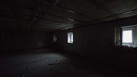 big dark room with low ceiling and little windows. dirty premise interior with light coming from windows.
