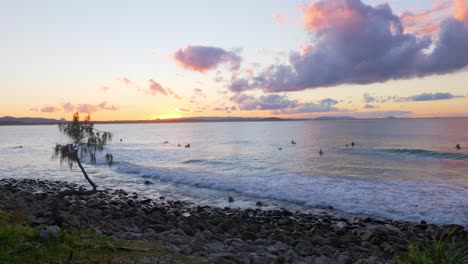 Surfistas-Y-Turistas-Nadando-En-La-Playa-En-Noosa-Heads,-Australia-En-Una-Puesta-De-Sol