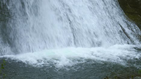 immerse yourself in the serene beauty of nature as we explore the tranquil depths at the bottom of a majestic waterfall