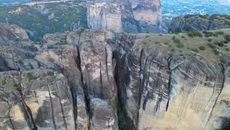 volando lentamente y cerca del cañón de arenisca en meteora, grecia, aéreo
