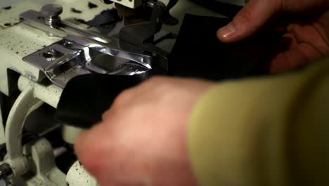manos masculinas recortando el borde del cuero en blanco. artesano trabajando