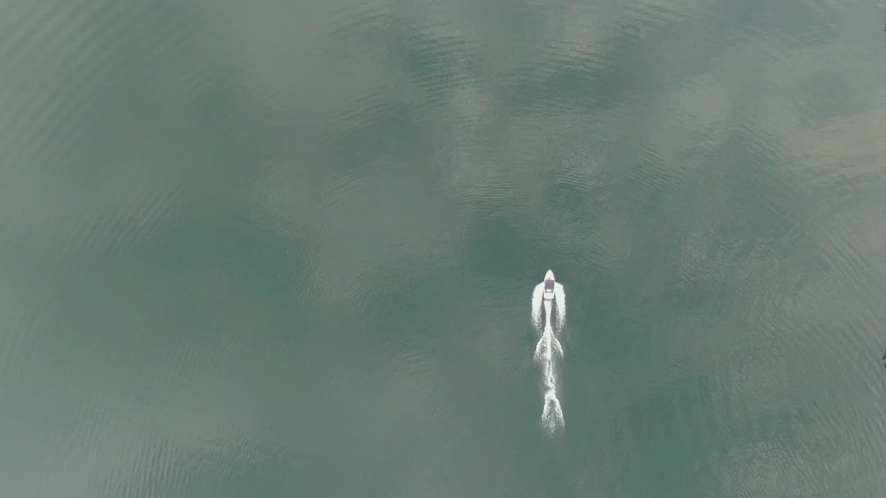 espectacular vista de pájaros del comienzo explosivo del esquiador acuático y el paseo en slalom saltando a través de la estela del barco