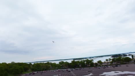 An-aerial-FPV-drone-view,-flying-over-a-large-parking-lot-on-a-cloudy-day