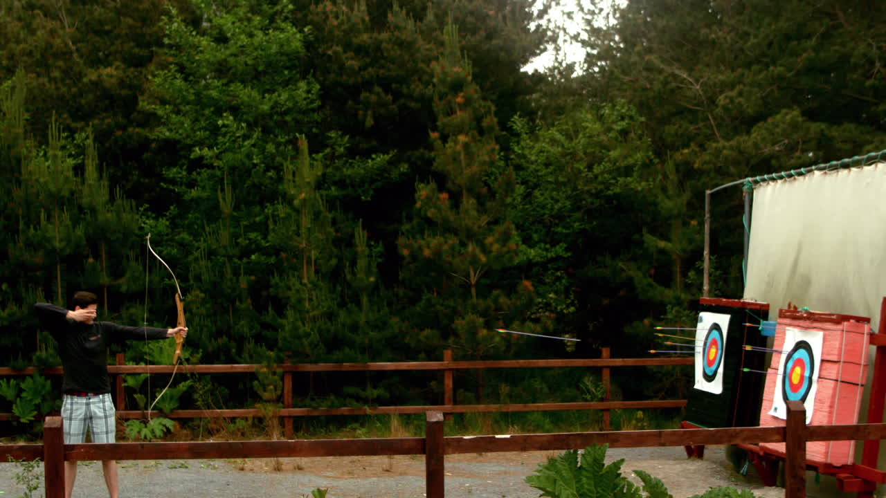 hombre atlético disparando un arco y una flecha al objetivo