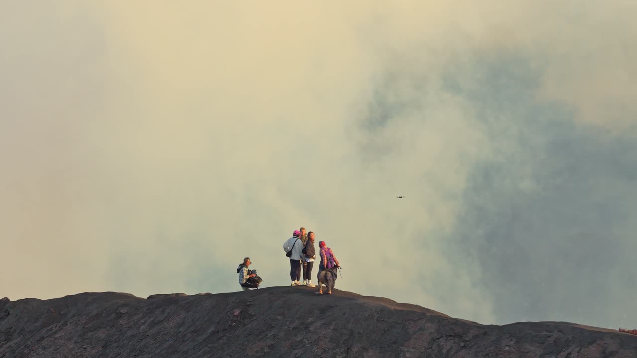 Piccolo gruppo di persone in escursione sul bordo del cratere del vulcano Monte Bromo