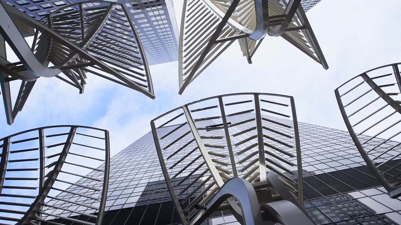 360 pan up of tall buildings in downtown calgary with some modern art on the street