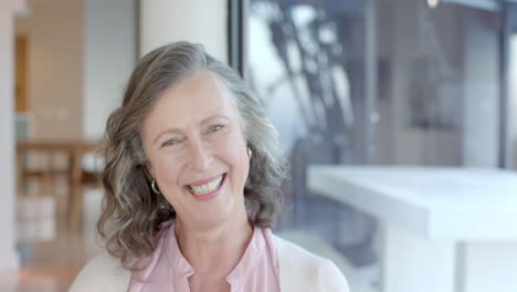 smiling senior woman enjoying vacation, laughing and looking at camera indoors