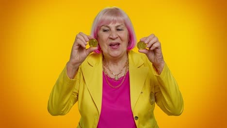 mature old stylish woman granny showing golden bitcoins cryptocurrency investment, mining technology