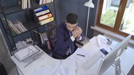 hombre de negocios ocupado hablando por teléfono y trabajando mirando papeles.