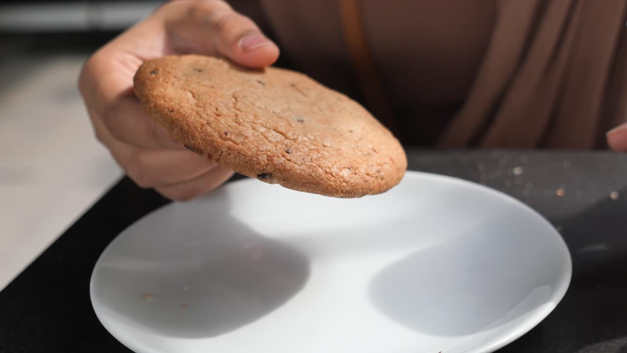 Woman eating a chocolate chip cookie