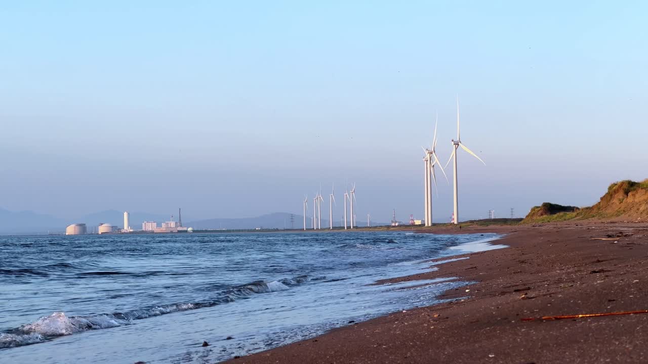 Wind turbines along Otaru Dream Beach at sunset, peaceful ocean waves and clear sky