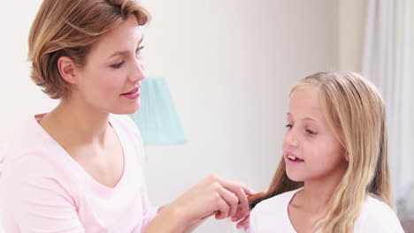 Lächelnde-Mutter-Kämmt-Die-Haare-Ihrer-Tochter