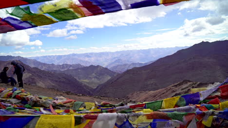 Push-in-shot-at-a-viewpoint-in-the-Himalayas,-as-the-camera-goes-between-Buddhist,-Tibetan-prayer-flags-revealing-endless-mountain-range