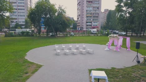 wedding venue with pink fabric and flowers in park aerial