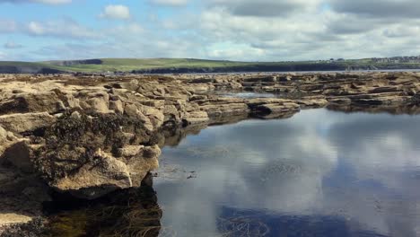 handheld pan shot of natural tidal pools along the rugged coast of ireland