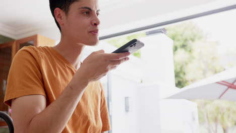 Happy-biracial-man-talking-on-smartphone-by-door-to-sunny-garden,-copy-space,-slow-motion