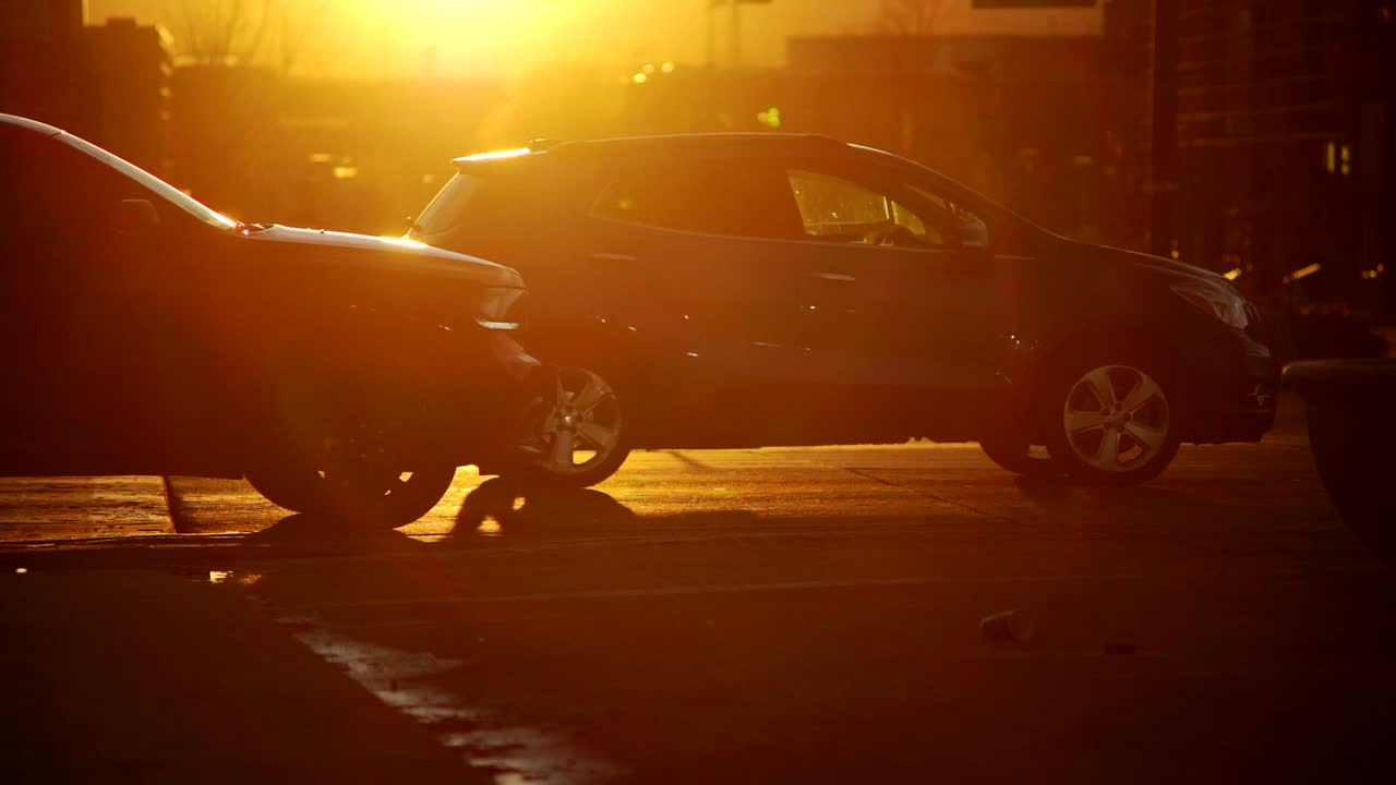 Cars driving in slow motion against a background of sunset