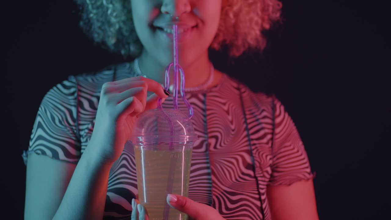 Woman Drinking Soda Under Neon Light