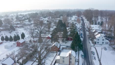 aerial establishing shot of homes covered in fresh snow during cold winter morning in usa