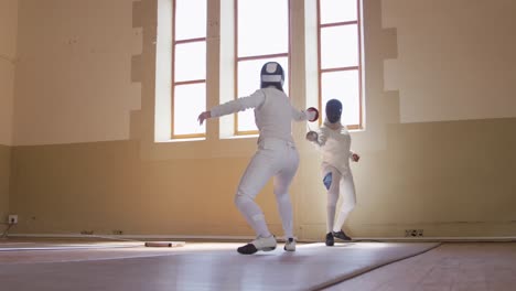 Fencer-athletes-during-a-fencing-training-in-a-gym