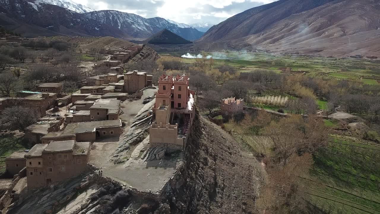 A tiny Berber village nestles among Morocco's Atlas Mountains, its traditional stone houses blending harmoniously with terraced fields and ancient olive groves on steep hillsides
