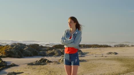 Young-woman-standing-at-beach-on-a-sunny-day-4k