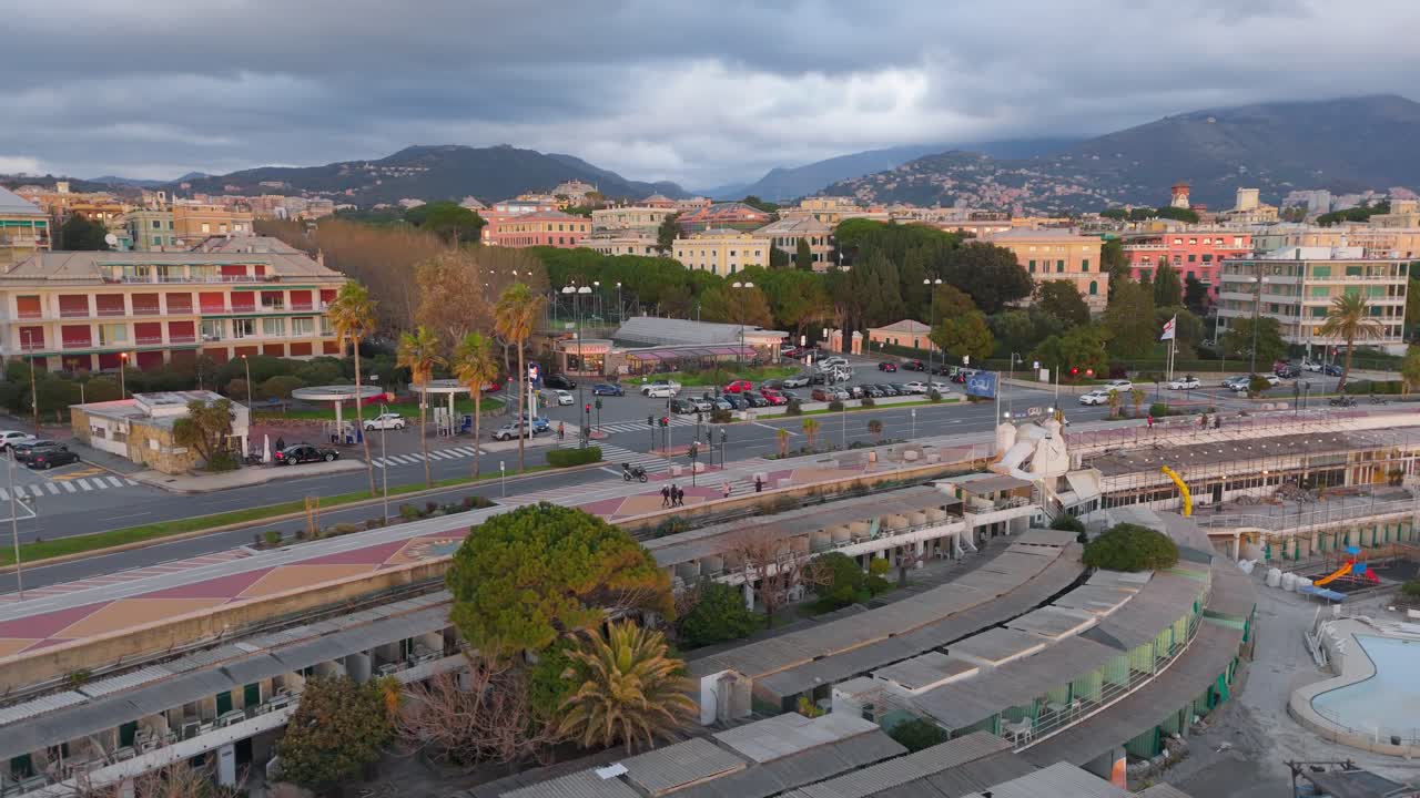 Paesaggio urbano di Genova con edifici, strade e auto, cielo nuvoloso, vista aerea.