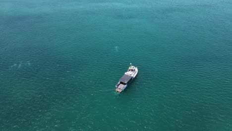 4K-Fishing-boat-in-turquoise-water-sea-aerial-shot