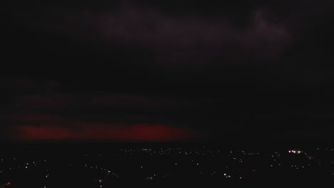 Imágenes-Aéreas-Deslizantes-De-Nubes-Rojas-En-El-Cielo-Con-Relámpagos-Intermitentes-Durante-La-Tormenta.-Farolas-En-La-Ciudad.-Valladolid,-México