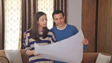 excited indian wife explaining house plan to husband