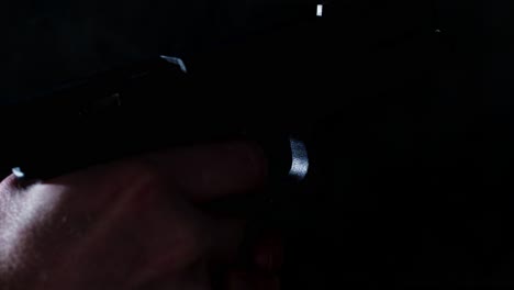 shell casing flying out of fired glock 17 handgun in slow motion in a dark room