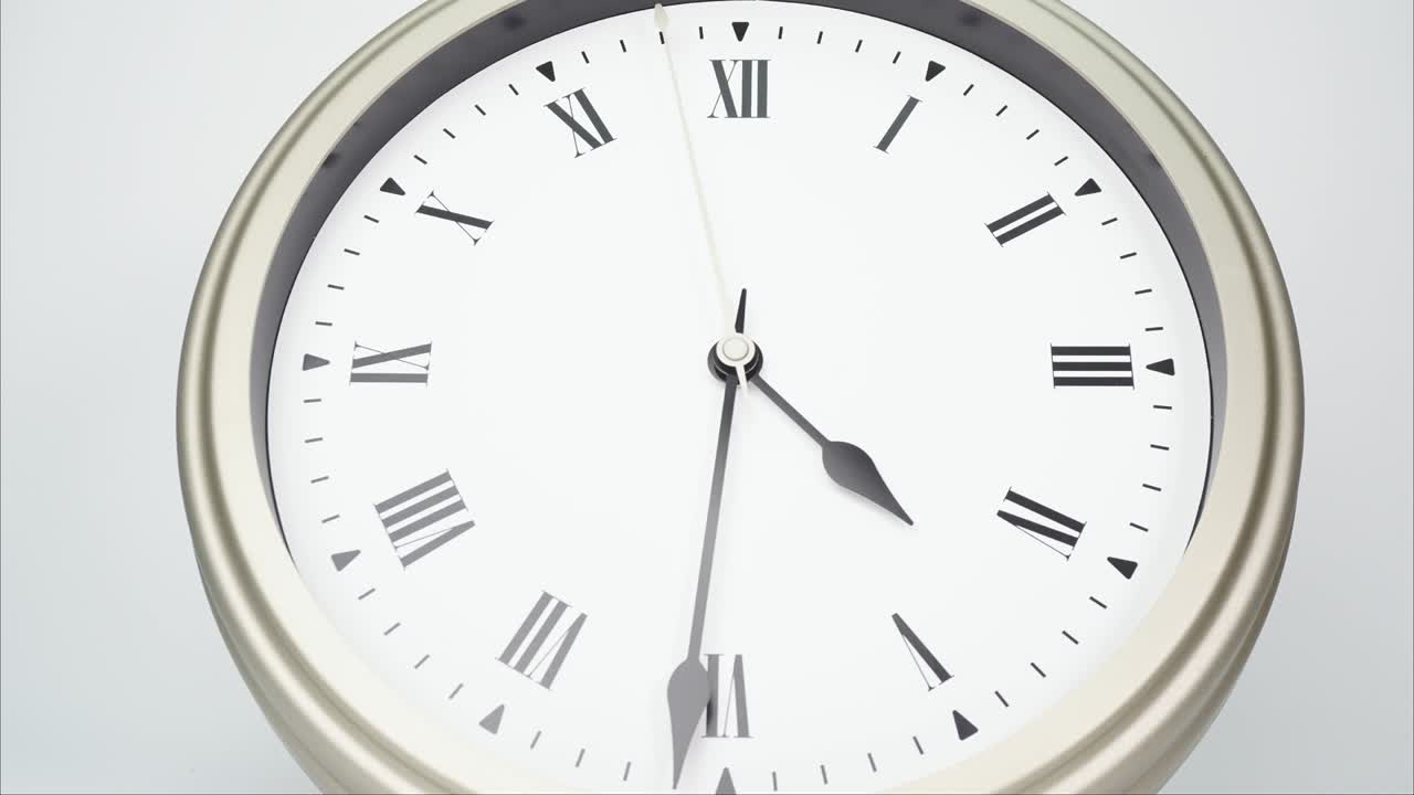 el reloj de pared de plata indica la hora a las cinco.