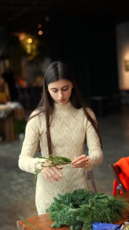 mujer haciendo una corona de navidad