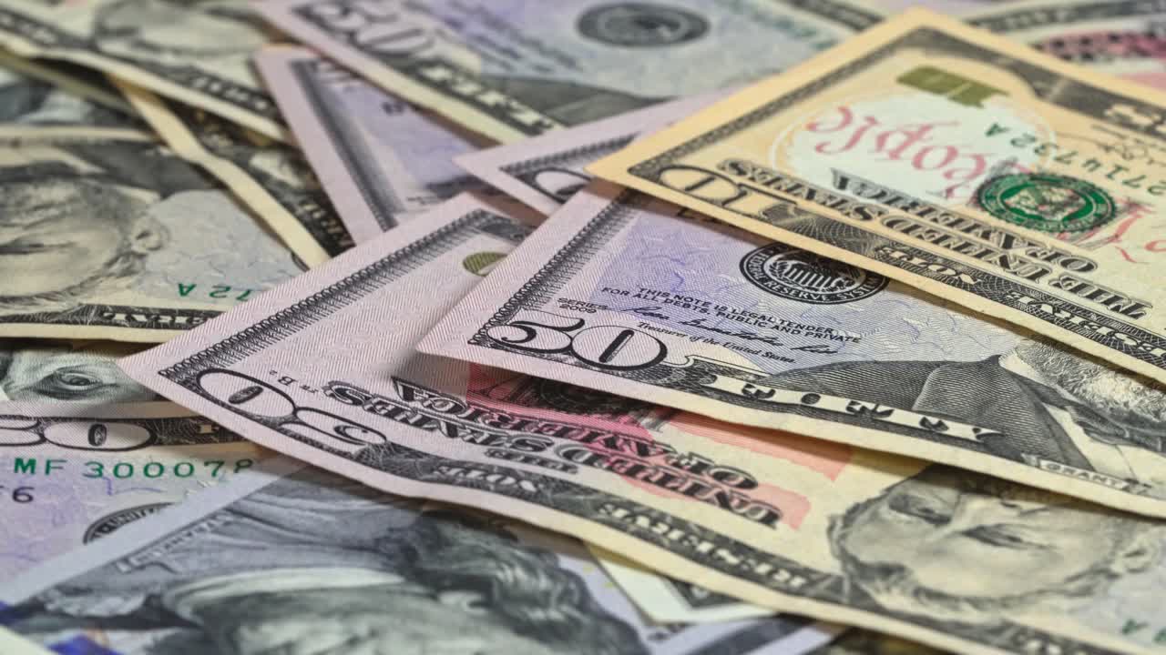 Various currency bills on a table with different denominations present