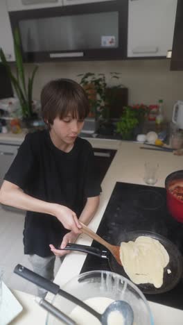 a young boy cooking pancakes