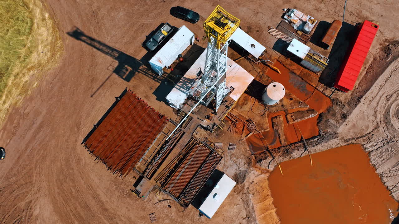 Flying circles around the site for production natural resources. Cars, metal pipes and a pool filled with orange water.